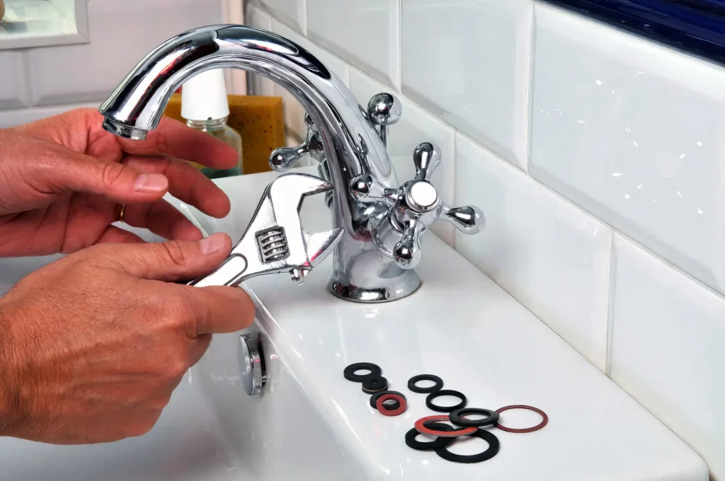 Plumber performing maintenance on a bathroom faucet in Delray Beach