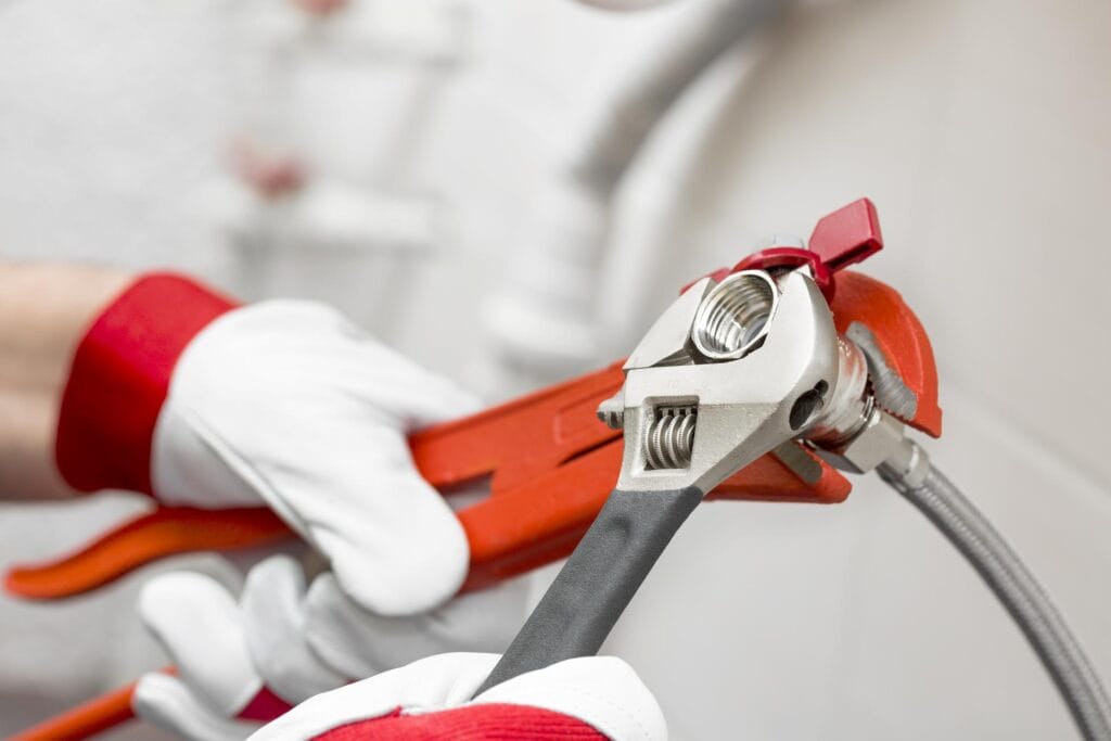 Plumber holding pipe wrenches for an emergency repair in Delray Beach