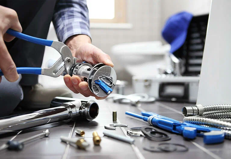 Technician repairing a plumbing fixture with professional tools in Delray Beach