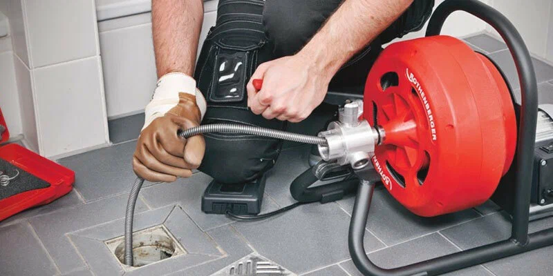 Plumber using a drain-cleaning machine in Delray Beach