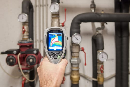 Plumber using a thermal imaging camera to inspect pipes in Delray Beach