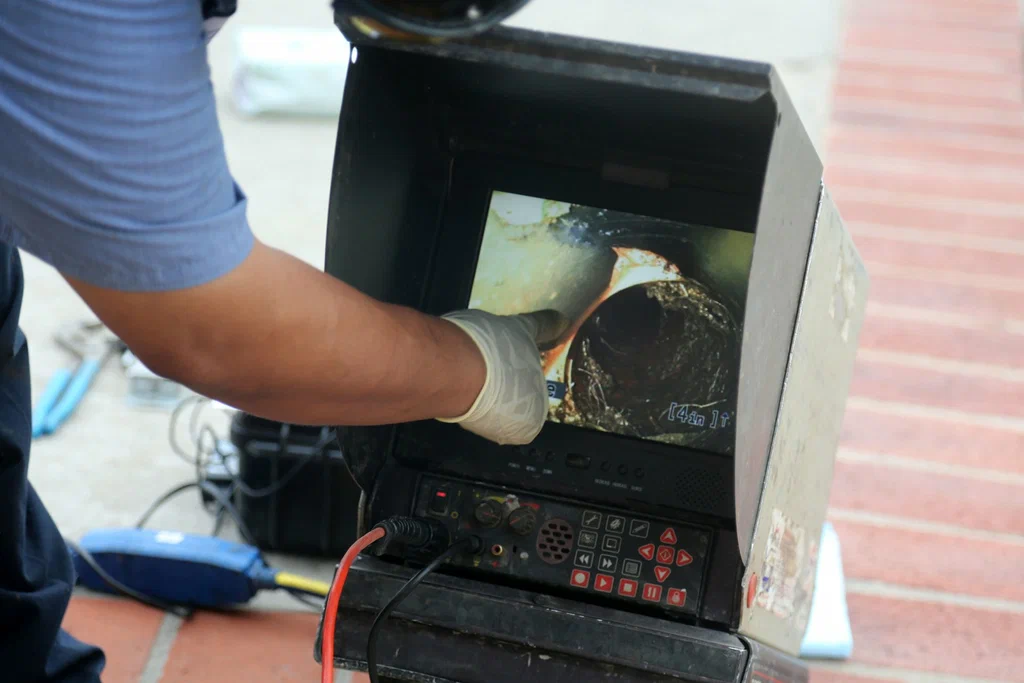 Technician viewing a drain inspection camera in Delray Beach
