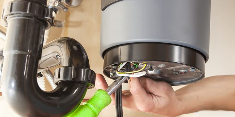 Technician repairing the heating element of a water heater in Delray Beach