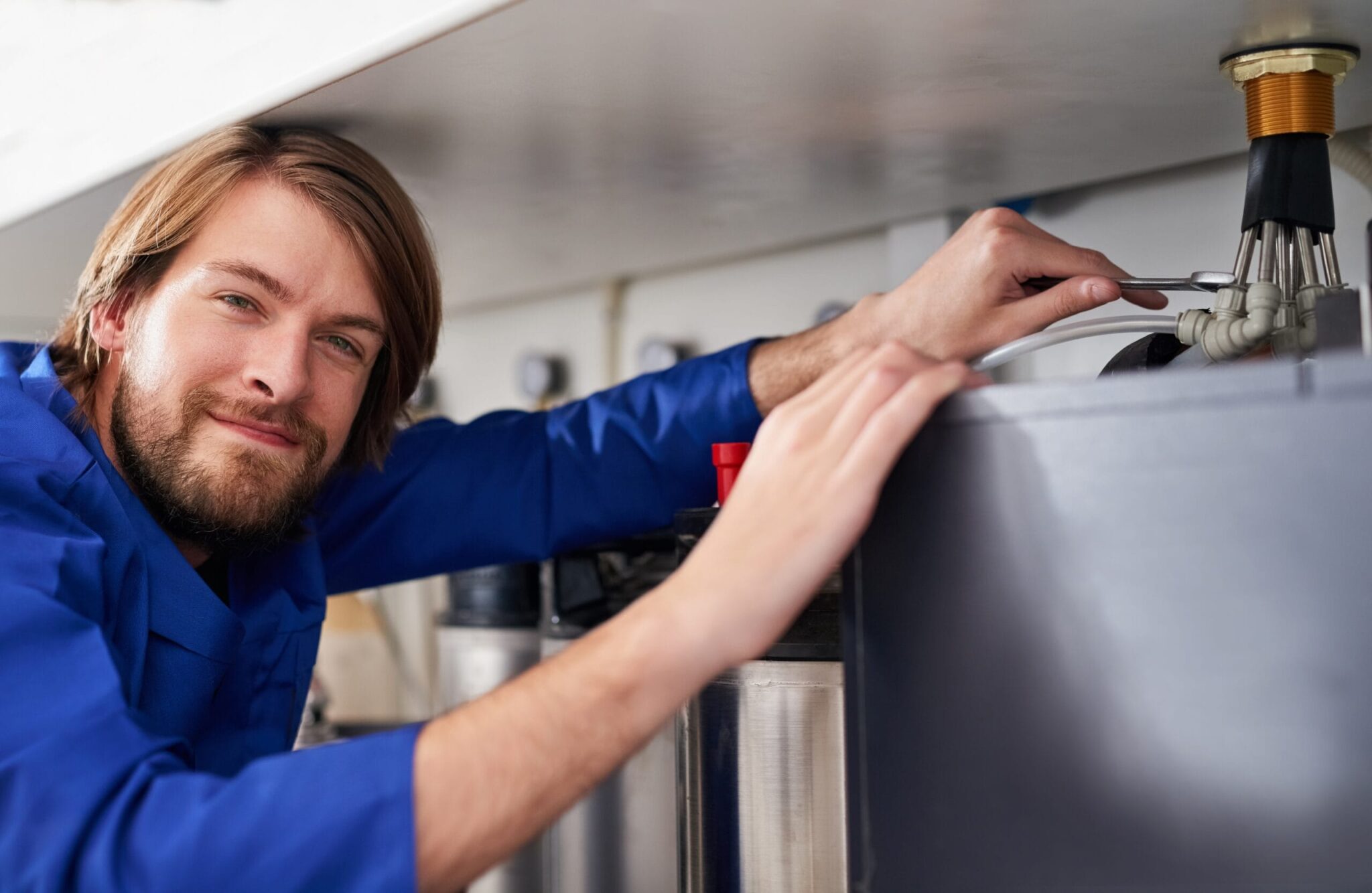 Technician servicing a residential water heater tank in Delray Beach