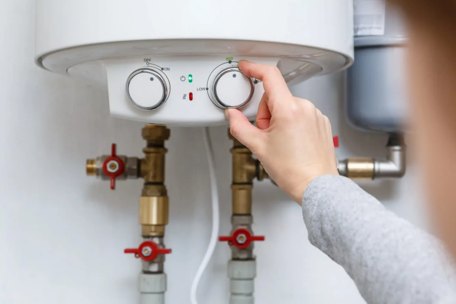 Homeowner adjusting the temperature controls on a water heater in Delray Beach