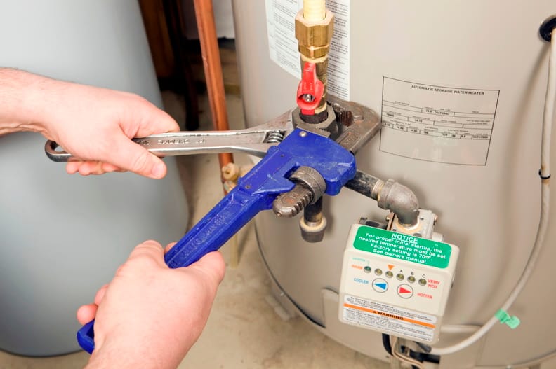 Plumber repairing a water heater valve in Delray Beach